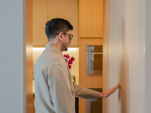 A home inspector checking a wall beside a modern kitchen