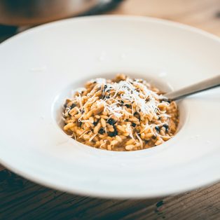 A plate of mushroom risotto on a wooden table