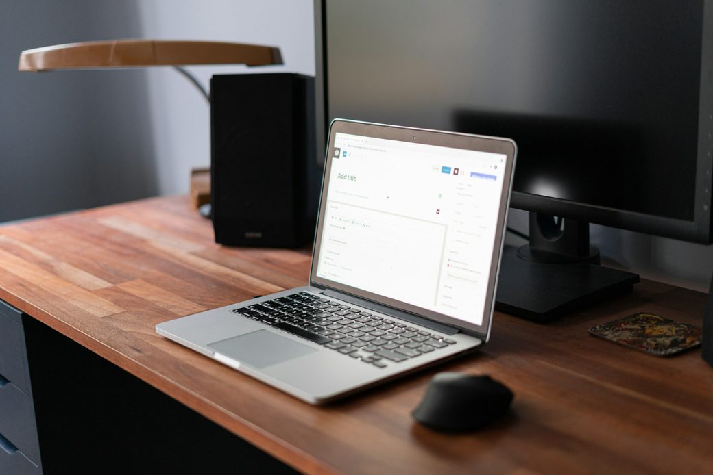 A laptop showing the redesigned Pebble inbox on a wooden desk