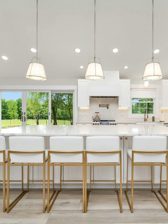 The kitchen after: a long white island under big windows