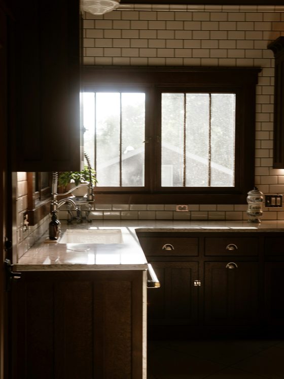 The galley kitchen before: dark cabinets and one small window