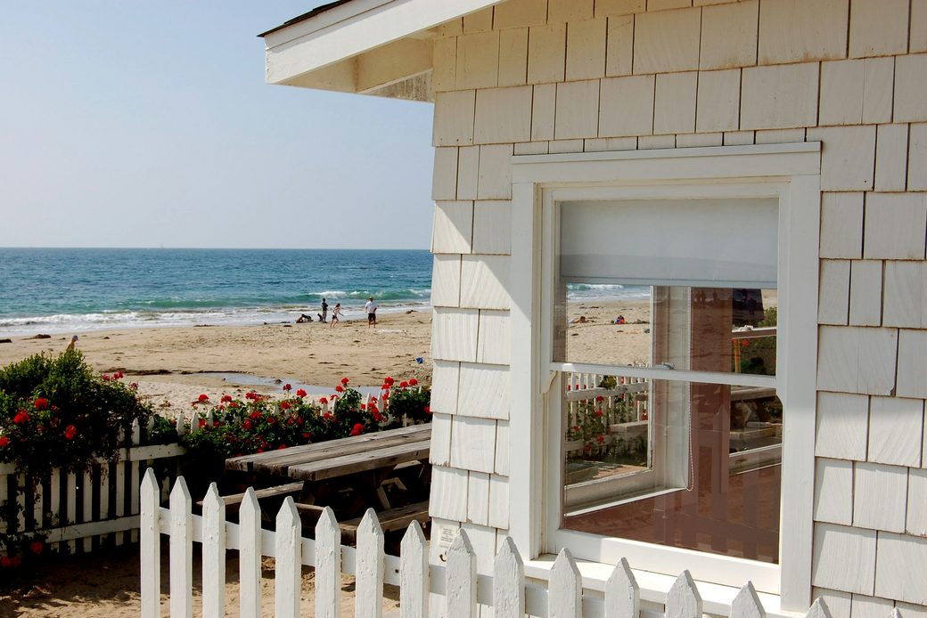 The cottage from the garden gate, with the beach behind it
