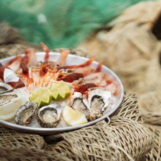 Oysters and prawns on a platter set on fishing nets