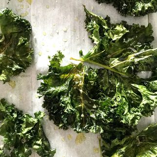 Fresh kale leaves spread across a pale counter