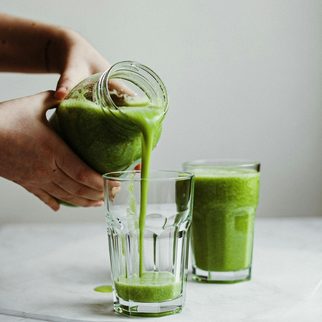 A green drink poured from a jar into a glass