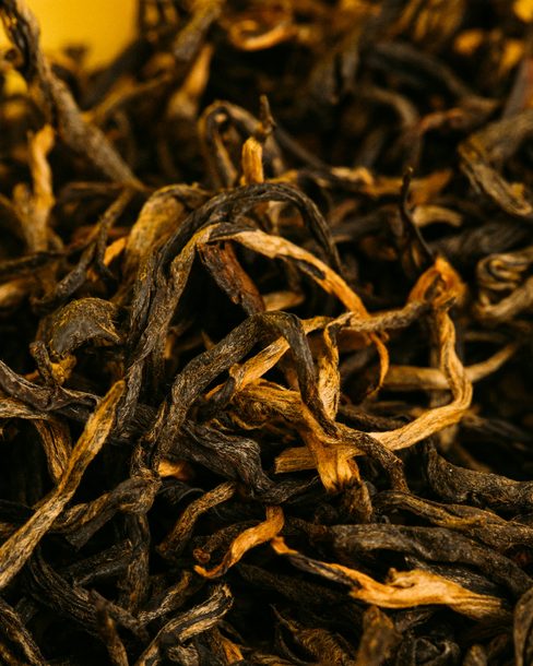 Twisted black tea leaves with golden tips, close up