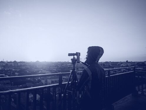A camera operator filming the city at sunset