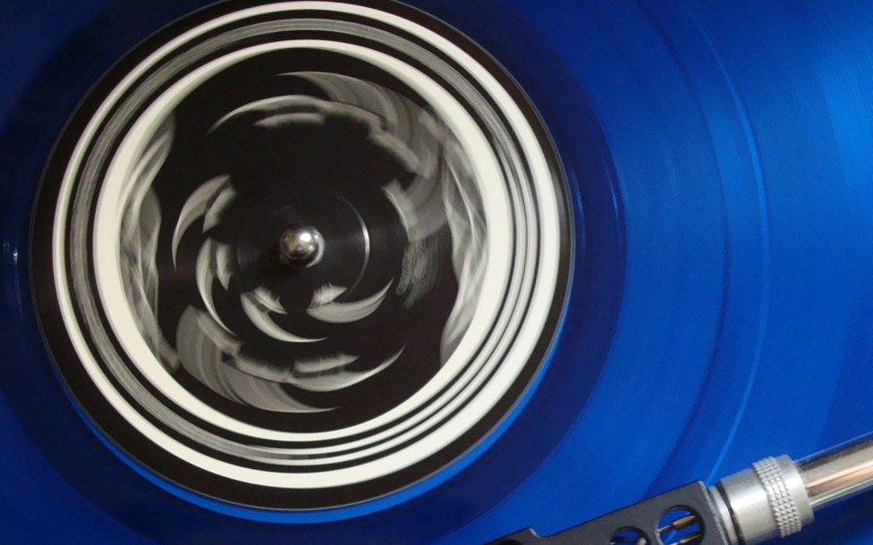A blue vinyl record spinning on a turntable