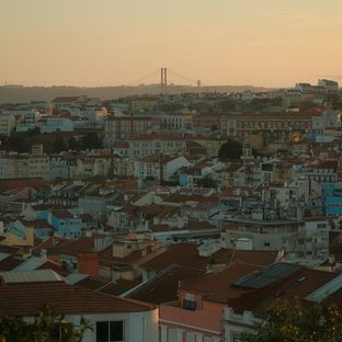 Rooftops of a hillside city at sunset