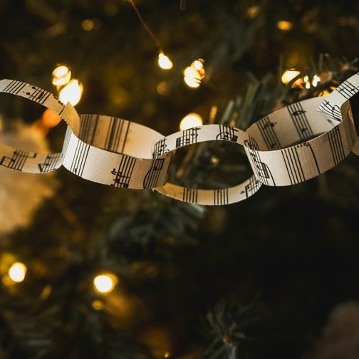 A paper garland of sheet music among warm tree lights