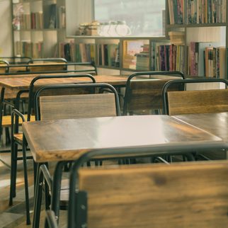 Wooden library tables in front of full bookshelves