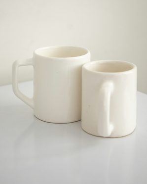 Two cream ceramic mugs side by side