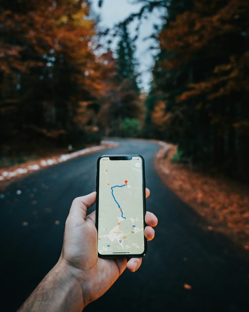 A hand holding a phone showing a route on a map