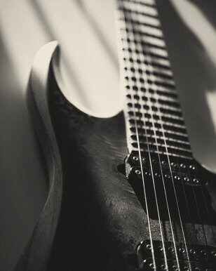 Close-up of an electric guitar body and strings in hard light
