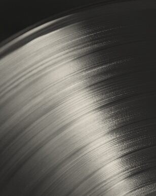 Close-up of a vinyl record's grooves catching the light