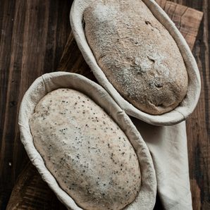 Two loaves proving in cane baskets