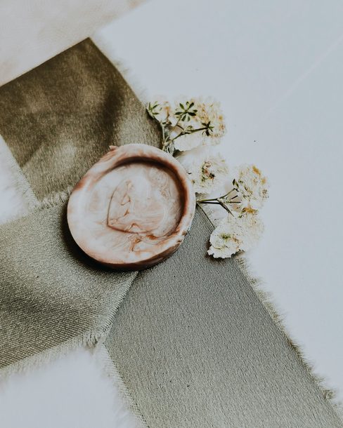 A wax seal on an olive ribbon with small dried flowers