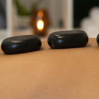 Smooth dark stones laid in a line along a client's back
