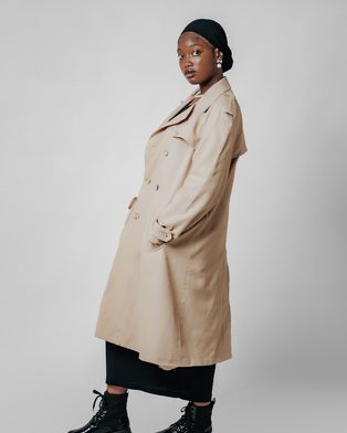 A woman in a long beige trench coat