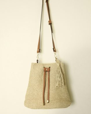 A raffia bucket bag with a tan leather strap