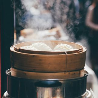 A bamboo steamer of dumplings at a market stall