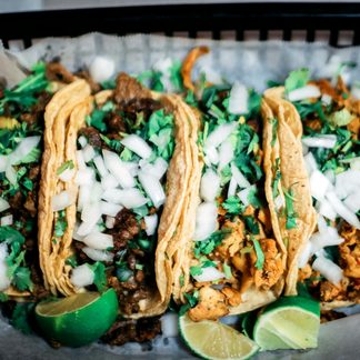 A tray of tacos topped with onion and coriander