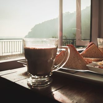 Hot chocolate and toast on a table by a window