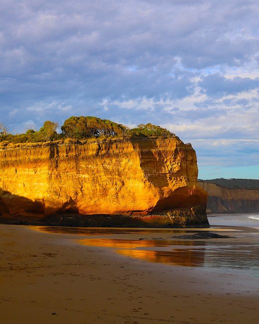 Golden cliffs above a wide beach at sunset