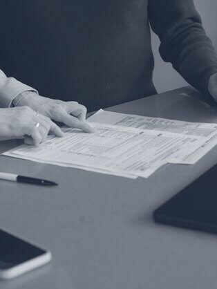 Two people reviewing printed reports at a table