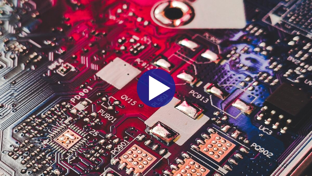 Video still: a circuit board lit in red, close up