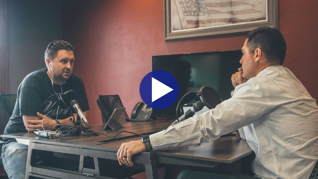 Video still: two people seated facing each other in an interview setup