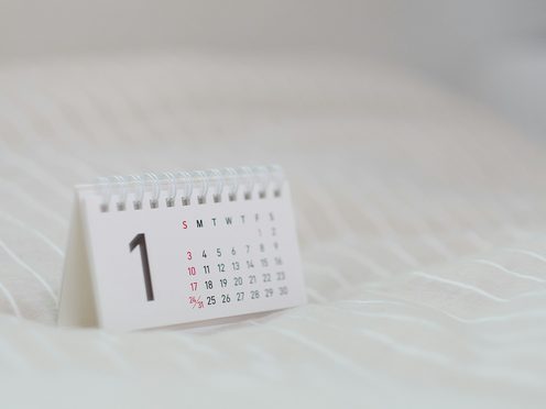 A white paper calendar lying on white linen