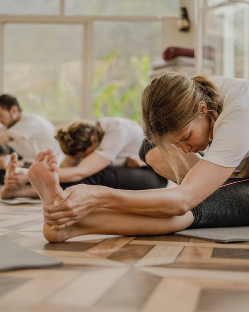 A small yoga class resting on mats in a calm studio